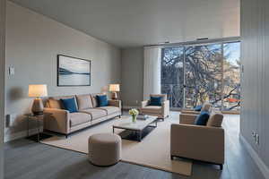 Living room with a wall of windows and wood finished floors