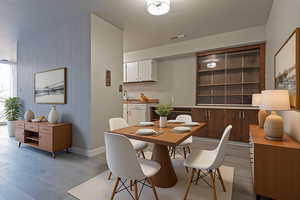 Dining space with light wood finished floors and wood walls