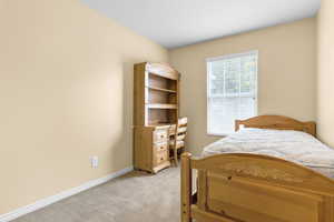 Bedroom with light carpet and baseboards