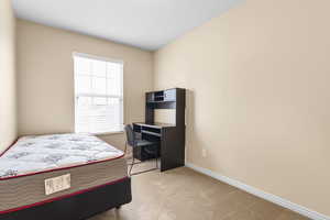 Bedroom with light colored carpet and baseboards