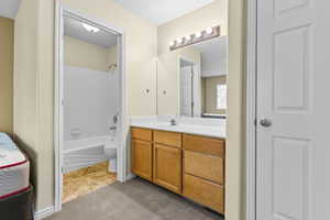 Full bath with vanity, shower / bathtub combination, light tile patterned floors, and light colored carpet