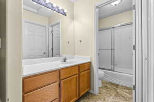 Full bath with vanity and bath / shower combo with glass door