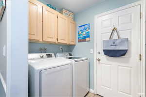 Laundry area featuring cabinet space and separate washer and dryer
