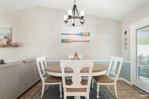 Dining area with vaulted ceiling and a chandelier