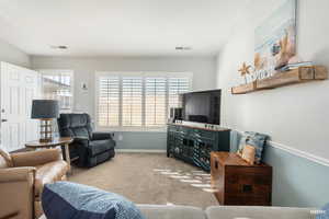 Carpeted living area with healthy amount of natural light.