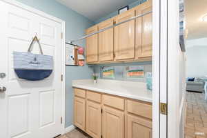 Laundry area featuring cabinetry and light countertops with convenient laundry bar.