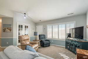 Living area featuring vaulted ceiling, French doors to the flex room, and carpet living room area.