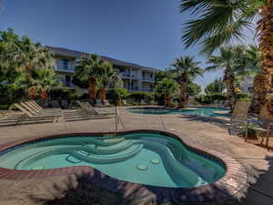 Community pool with a patio area and a community hot tub