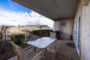 View of patio featuring outdoor dining space, a grill, and a mountain view