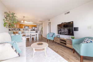 Living area with a chandelier, light wood-type flooring, and recessed lighting