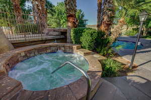 Outdoor pool featuring an in-ground hot tub and a patio area