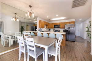 Dining space featuring recessed lighting, dark wood-style floors, and a chandelier