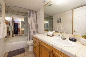 Bathroom with vanity, light tile patterned floors, and shower / tub combo with curtain