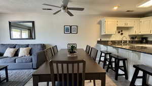 Dining space with light wood-style flooring and a textured ceiling
