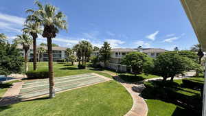 Surrounding community with shuffleboard and a lawn