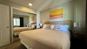 Bedroom with dark colored carpet and a closet