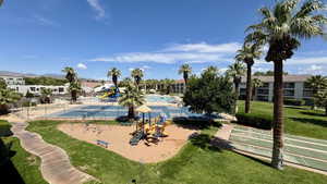 View of property's community featuring shuffleboard, a yard, and a swimming pool