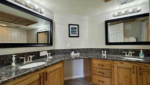 Full bathroom featuring two vanities and a textured ceiling