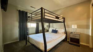 Bedroom featuring dark colored carpet