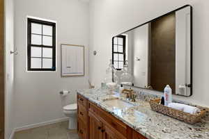 Bathroom featuring vanity, light tile patterned floors, and healthy amount of natural light