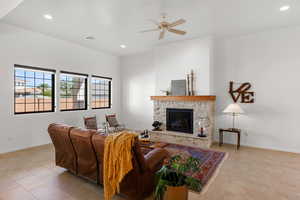 Living room featuring a stone fireplace, recessed lighting, ceiling fan, and light tile patterned floors
