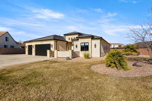Prairie-style house featuring stucco siding, concrete driveway, stone siding, and an attached garage