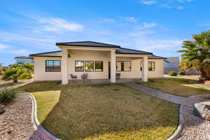 View of front facade featuring a front yard, a tiled roof, and stucco siding