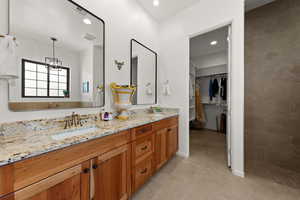 Full bath with double vanity, a walk in closet, light tile patterned floors, and recessed lighting