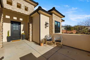 Entrance to property featuring stone siding and stucco siding