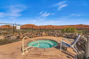 View of pool featuring a community hot tub, a patio, and a mountain view