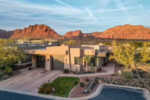 View of front of house featuring stucco siding, a mountain view, driveway, and a garage