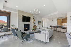 Living area with a chandelier, a tiled fireplace, recessed lighting, and light tile patterned flooring