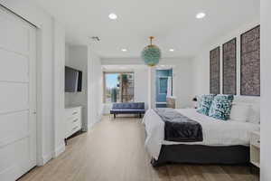 Bedroom with recessed lighting, light wood-style flooring, and ensuite bath