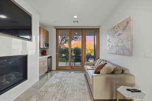 Living area featuring a tile fireplace, floor to ceiling windows, and light tile patterned flooring