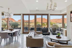 Sunroom / solarium with a mountain view, a chandelier, tile patterned flooring, and recessed lighting