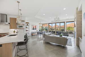 Living room featuring a mountain view, light tile patterned flooring, a chandelier, and recessed lighting