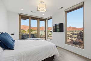 Bedroom with access to outside, floor to ceiling windows, light wood-style floors, and recessed lighting