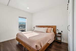 Bedroom with dark wood-style floors and a mountain view
