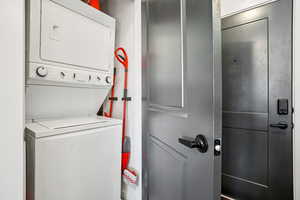Laundry area with stacked washer and clothes dryer