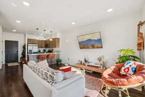 Living area with dark wood finished floors and recessed lighting