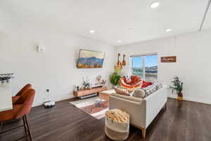 Living room featuring dark wood-style flooring and recessed lighting