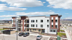 View of property with a mountain view and uncovered parking