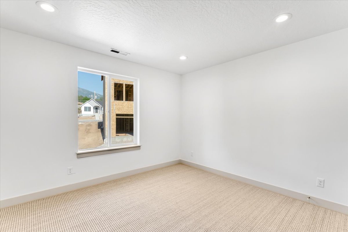 Room featuring a light-toned carpet, white walls, and a window with a sill