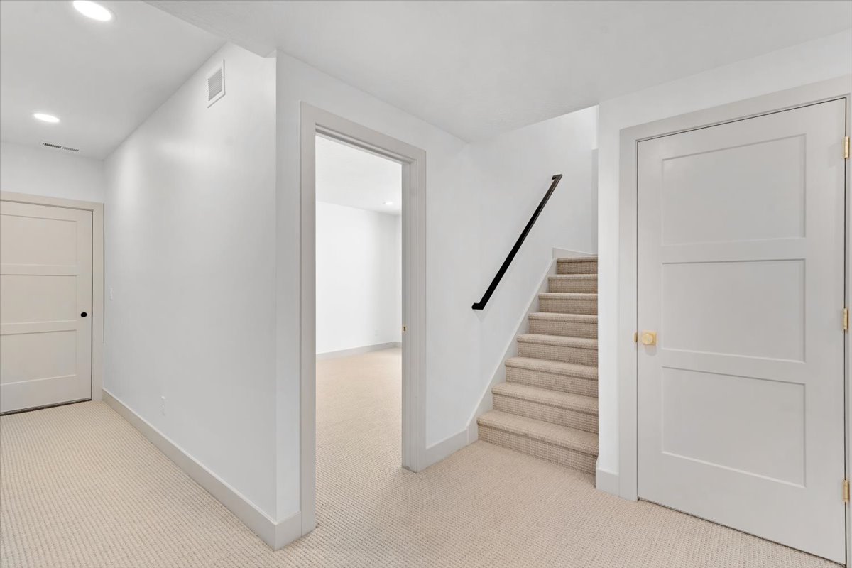 Carpeted stairway with a black handrail