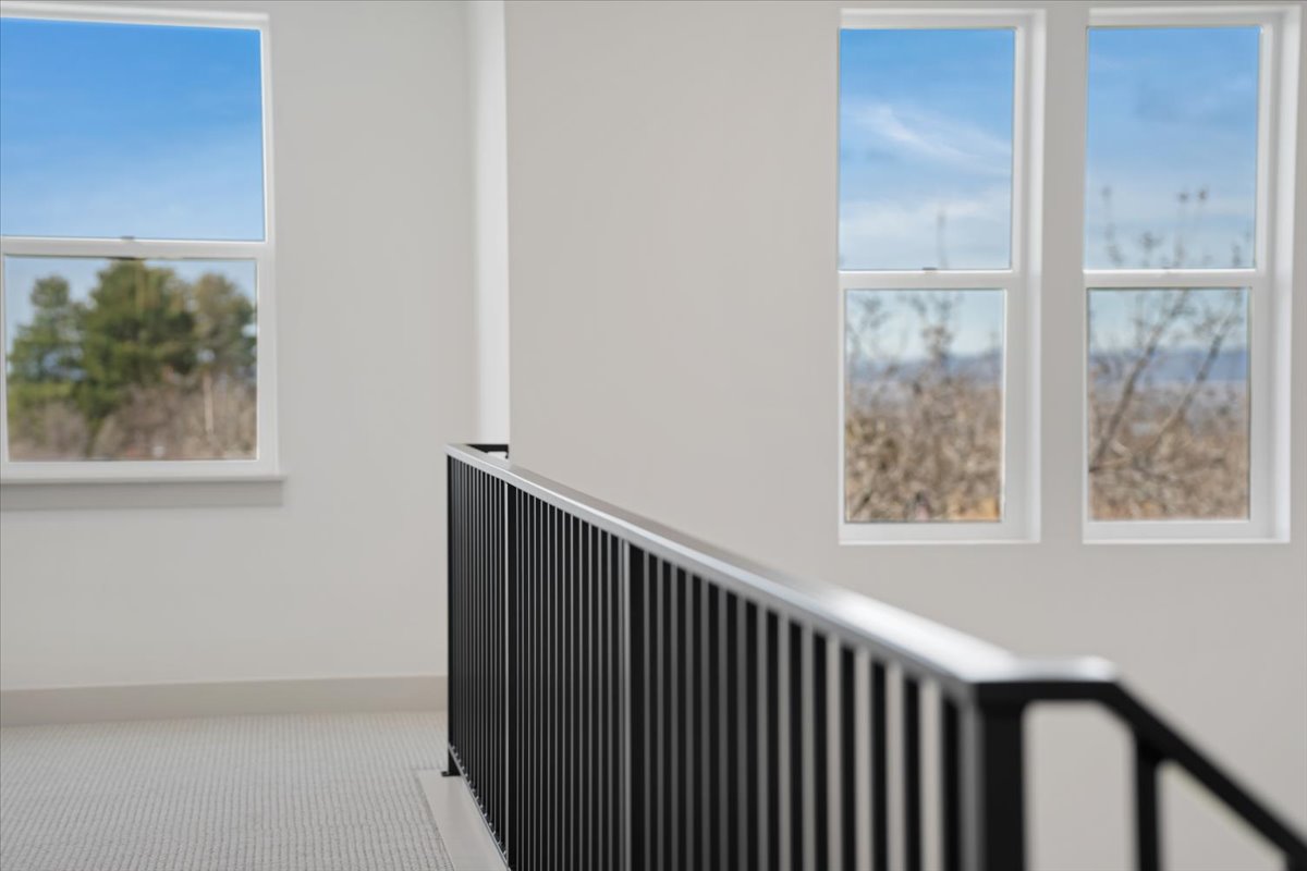 Upper-level hallway with white walls and light-colored patterned carpeting