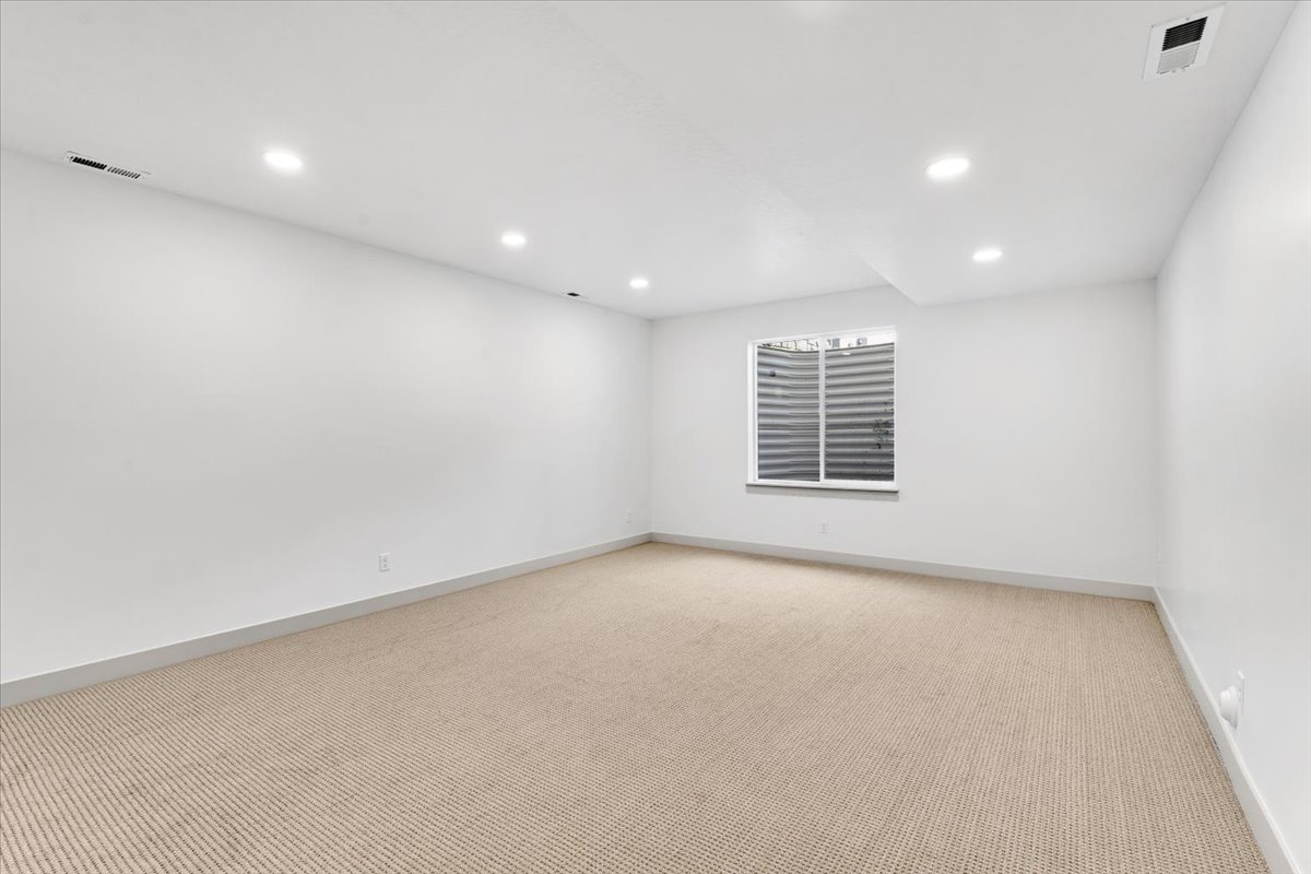 Carpeted room with recessed lighting and neutral wall tones