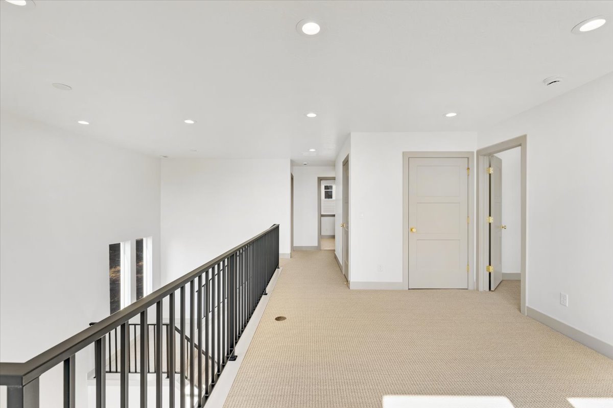 Open landing area featuring light-toned carpeting and recessed lighting