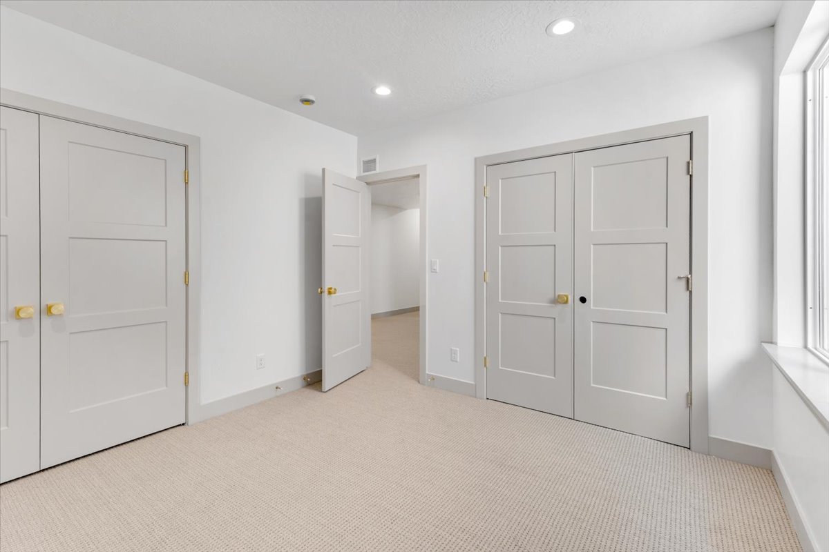 Soft carpeted flooring complemented by white walls and recessed lighting
