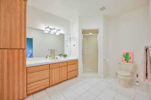 Bathroom featuring vanity, a stall shower, and light tile patterned flooring