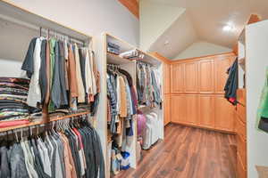Spacious closet with vaulted ceiling and dark wood-style flooring